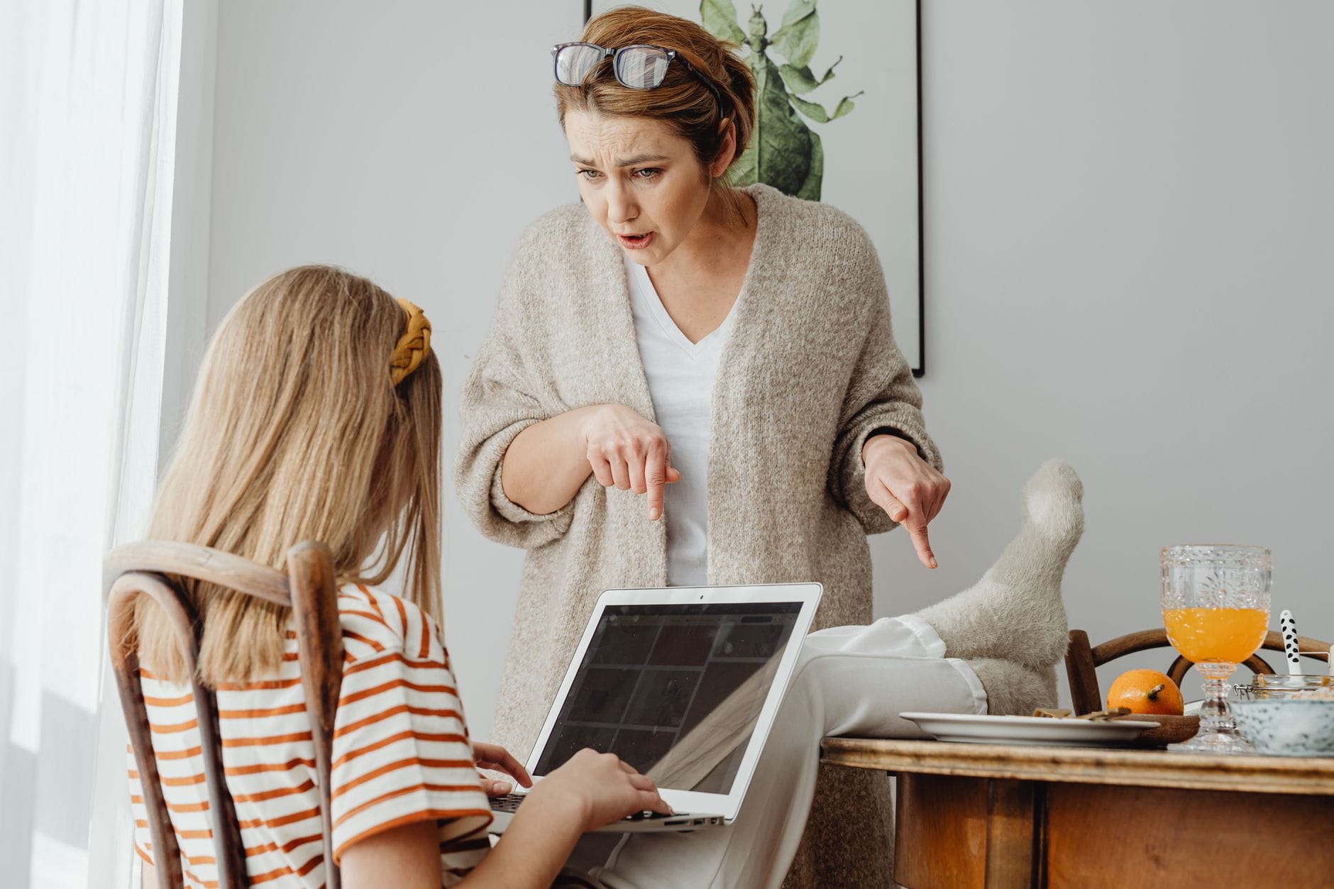 Mama karci nastoletnią córkę przy laptopie w domu